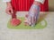 Professional butcher cutting eye of round roast on a green cutting board. Man dressed in white uniform and red and white stripe