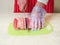 Professional butcher cutting eye of round roast on a green cutting board. Man dressed in white uniform and red and white stripe