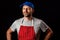 Professional butcher fishmonger in grey t shirt and classic red and white stripe apron and blue baseball hat. Man with beard in hi