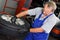 Professional car mechanician inflating tyre