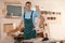 Professional carpenter in uniform near workbench