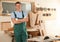 Professional carpenter in uniform near  workbench