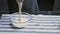 Professional chef is cooking cake. Young attractive chef pours white cream to glass bowl