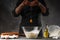 Professional chef cooks dough and breaks an egg. Freezing in motion, background for a bakery, recipe book, restaurant business and