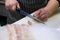 Professional chef cutting a fresh slices of salmon sashimi with a sharp knife. Japanese fresh seafood