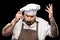 Professional chef in hat and apron tasting dish from ladle