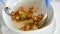 Professional chef mixing tomato avocado and other ingredients in a bowl