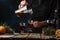 Professional chef pours mulled wine into glasses on rustic wooden table with festive composition background. Backstage of cooking