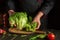 Professional chef prepares diet food from Lettuce. Tearing off green leaves on the kitchen table. The idea of a vegetable diet