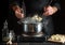 Professional chef prepares pelmeni in a saucepan in the kitchen. Close-up of a cook hands while working. Grande cuisine