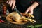 Professional chef prepares to cut raw rooster with a knife on a kitchen cutting board. Cooking chicken with spices for lunch