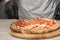 Professional chef preparing Italian oven baked pizza in restaurant