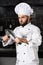 Professional chef at restaurant kitchen. Portrait of cook with crossed knives.