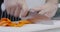 Professional chef slicing fresh carrots on cutting board