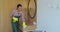 Professional cleaner in uniform wiping dust from the furniture in the hotel room or apartment bedroom. Cleaning service