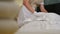 Professional cleaning service. Close-up of chambermaid in unifrom making bed and beating and arranging pillows preparing