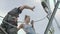 Professional climber with woman near the network tower at the roof