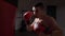Professional coach boxer offering punching lessons in a dark gym in slow motion -