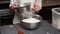 a professional confectioner pours flour into the dough