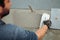 Professional construction worker laying adhesive and placing ceramic tiles