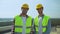 Professional construction workers in safety helmets and jackets smiling camera