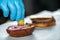 Professional Cook placing sliced pickles to a burger close up