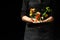 Professional cook. He prepares a dish with vegetables in a saucepan. on black background, menu, recipe book, healthy food