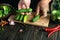 Professional cook sorts cucumbers before canning in a jar. Work environment on kitchen table with vegetables and spices