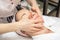 Professional cosmetologist massages skin of young woman with fingers, spa and cosmetology concept