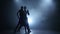 Professional couple of salsa dancers posing in smoky studio, silhouette