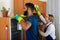 Professional couple in uniform cleaning at domestic interior