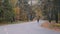 Professional cyclist in black helmet and cycling apparel is intensive training on road bike in fall city park. Male young athlete