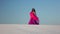 Professional dancer in the sandy desert in the hands of a pink pink veil. Slow motion