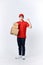 Professional delivery guy employee man in red cap T-shirt uniform workwear work as dealer courier hold cardboard box show muscles