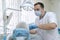 Professional dentist in protective mask working with elderly patient in dental clinic