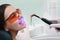 Professional dentist working with patient in clinic, closeup. Teeth whitening