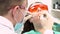 Professional dentist working with patient in modern clinic, medicine concept. Media. Young patient in protective glasses