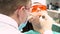 Professional dentist working with patient in modern clinic, medicine concept. Media. Young patient in protective glasses