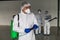 Professional disinfector removing infections coronavirus covid-19 from surfaces. male in protective suit use special equipment