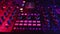 Professional DJ adjusts fader on digital music console in neon light, closeup. Concept modern club music