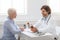 Professional doctor telling pills schedule to senior patient