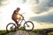 Professional Down Hill Cyclist Resting with Bike on the Rock at Sunset. Extreme Sport.