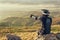 A professional downhill rider Points with a finger at the landscape sits on a stone resting after a tense race on a mtb