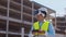 Professional drone operator in virtual reality helmet standing in front of construction site. Builder holding remote