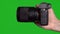 Professional DSLR photo camera with lens at green background. Chroma key.