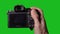 Professional DSLR photo camera with lens at green background. Chroma key.