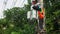 A professional electrician performs installation work on a pole. An electrician in professional equipment, working in dangerous co