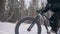 Professional extreme sportsman biker riding fat bike in outdoor. Cyclist ride in winter snow forest. Man does trial