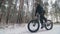 Professional extreme sportsman biker riding a fat bike in outdoors. Cyclist ride in the winter snow forest. Man does