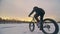 Professional extreme sportsman biker riding a fat bike in outdoors. Cyclist ride in the winter on snow ice. Man does